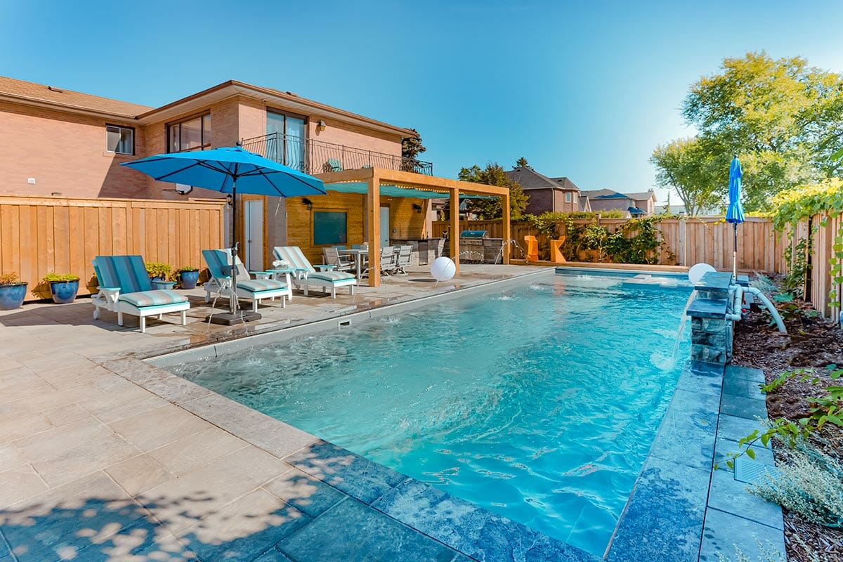 Toronto Landscaping Project; Featuring Fiberglass Pool Construction with Water Features, Interlocking, Outdoor Fireplace, Outdoor Kitchen & Pergola 