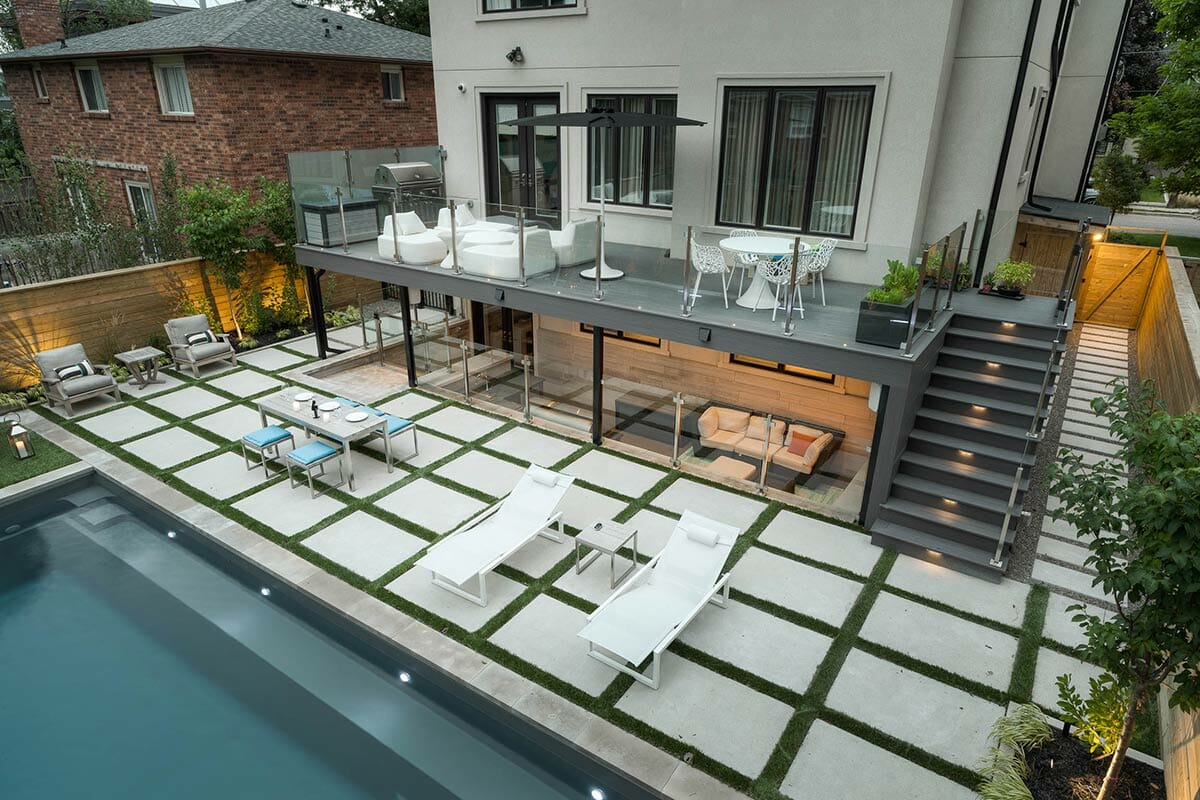 Joicey Blvd, Toronto two level composite deck construction and landscaping Project; Featuring Fiberglass Pool Installation, Interlocking, Decking, Outdoor Kitchen & Stainless Steel Glass Railings