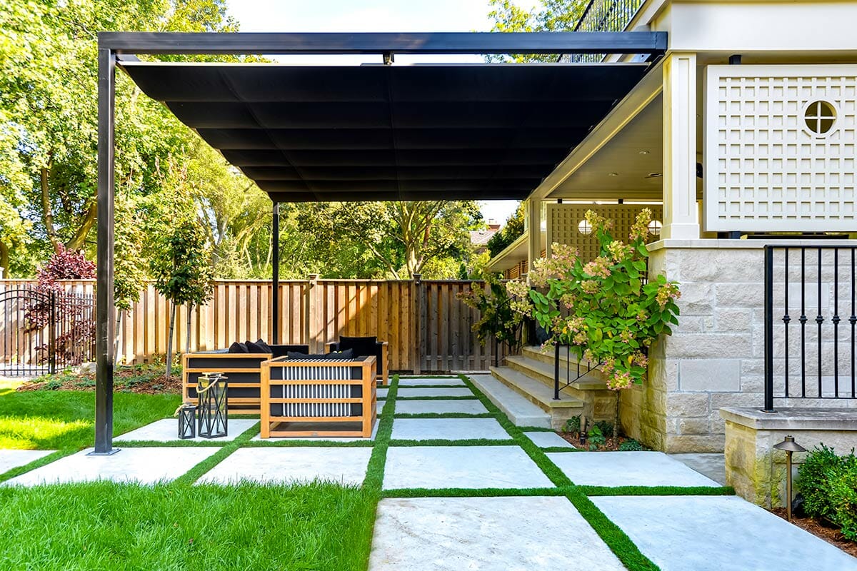 Toronto, Ridley Backyard Landscaping Design & Construction Project; Featuring Retractable Pergola, Interlocking, Outdoor Fireplace & Cedar Privacy Fence.