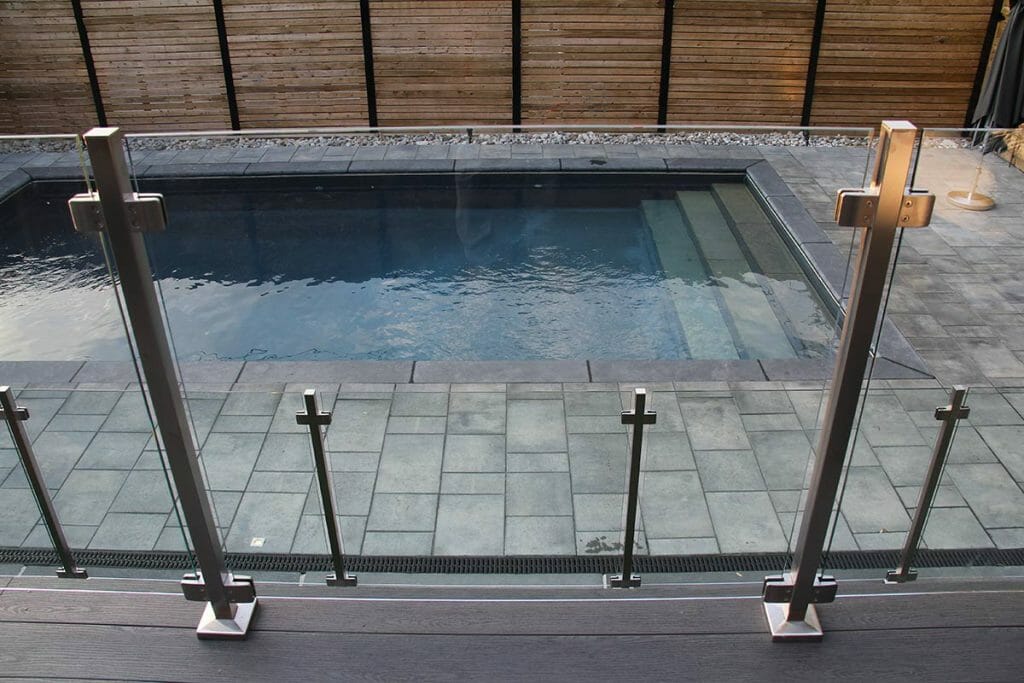 Complete Decking and Railings Project by Toronto Landscaping Company; Featuring Stainless Steel & Glass Railings, Fence Construction, Concrete Pool & Interlocking.