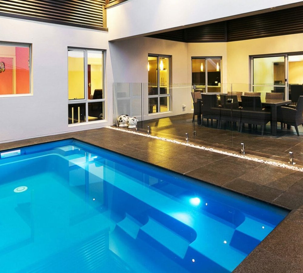 Harmony Fiberglass Pool with coping and lighting by M.E. contracting pool builders