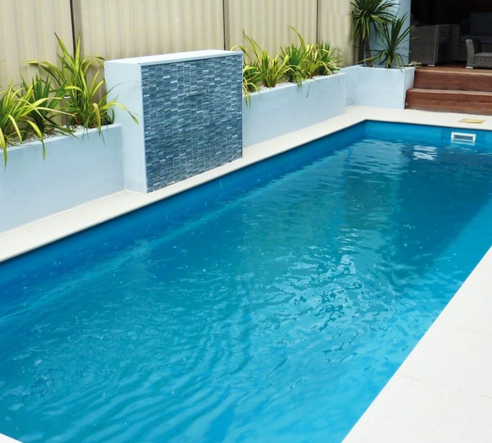 Rectangular Harmony fiberglass pool installed with water feature by M.E. contracting