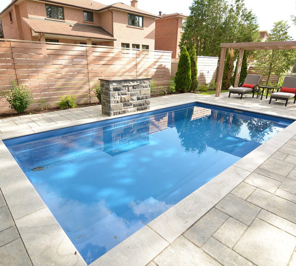 Reflection Fiberglass Pool installation with Water Feature, Interlocking & IPE Privacy Fence Backyard construction Project by Toronto pool Company.