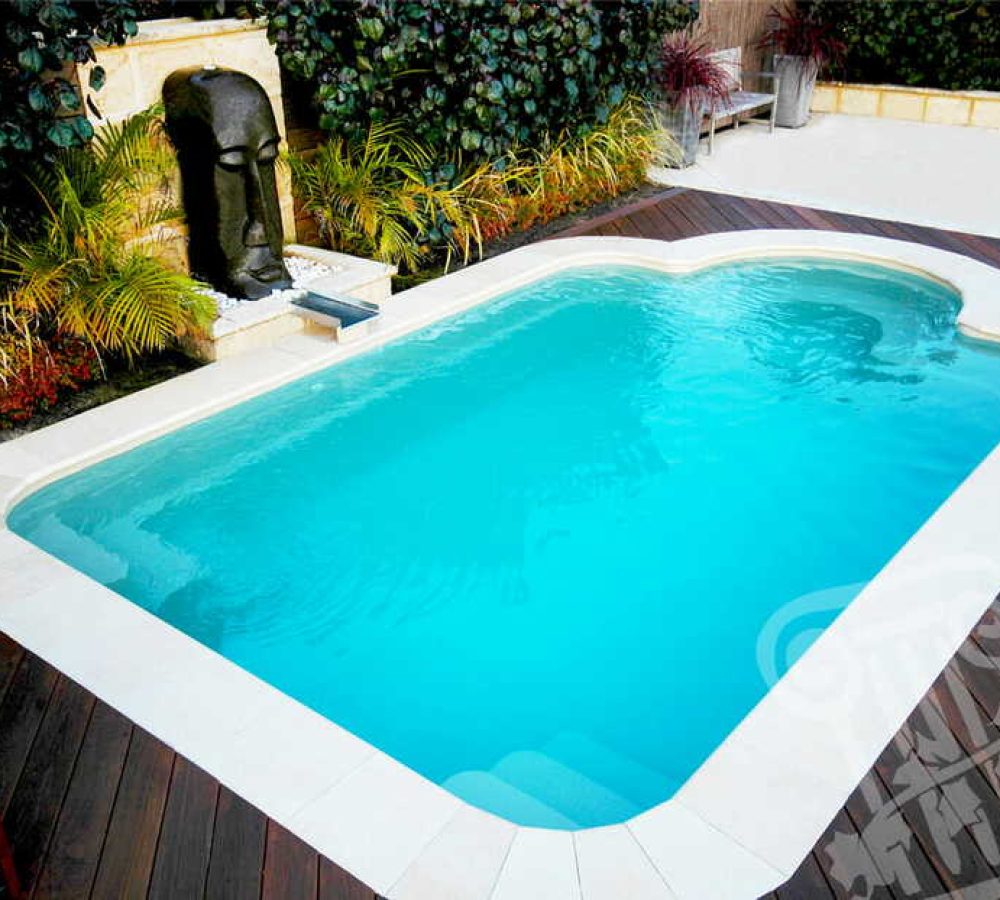 Fiberglass pool styled in Courtyard Roman design with water feature and coping